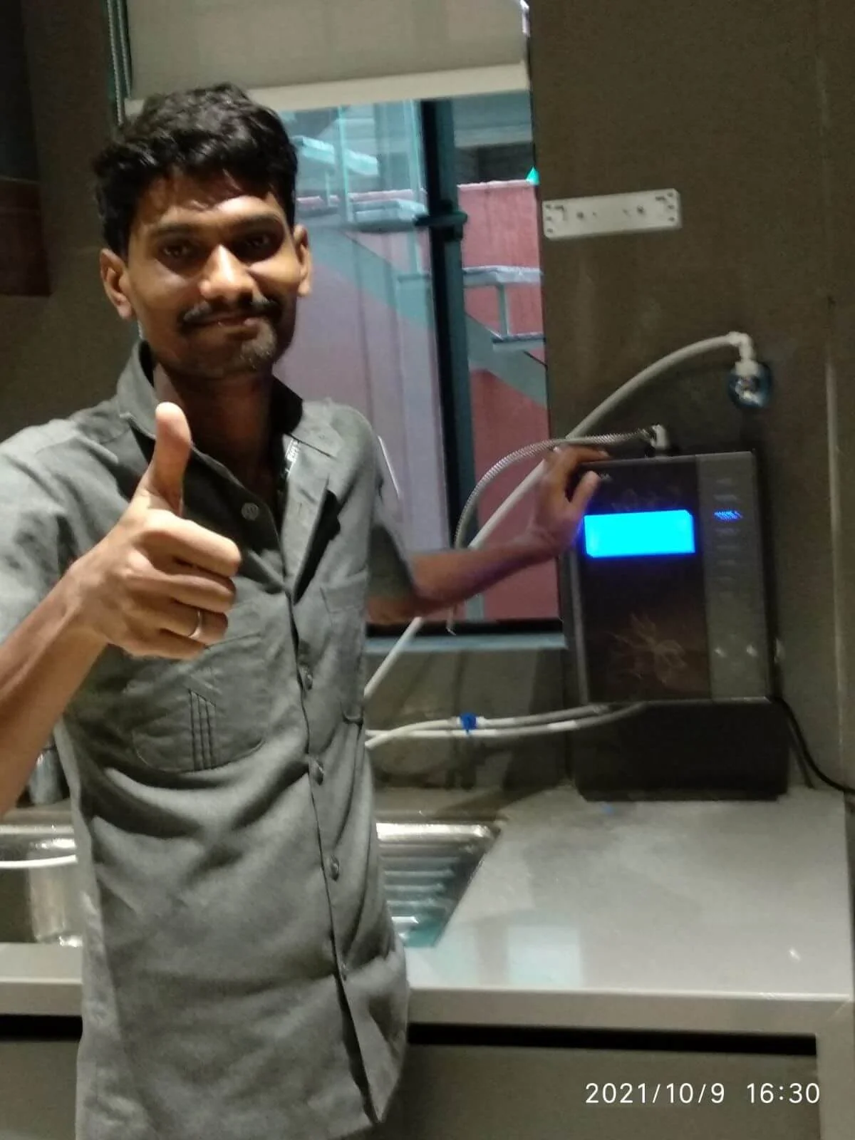 Male user quenching his thirst using the Chanson Quality Water Purifier