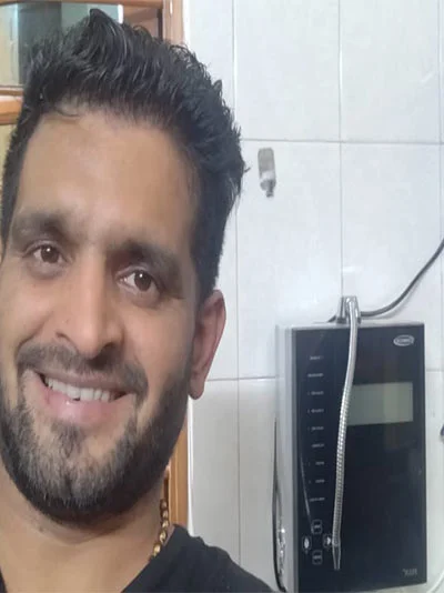 Male user quenching his thirst using the Chanson Quality Water Purifier