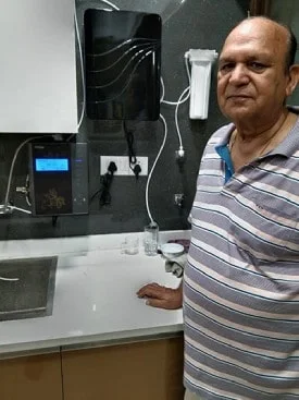 Man assured of his water's purity with the Chanson Quality Water Purifier