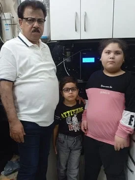 Male standing next to his trusted Chanson Quality Water Purifier