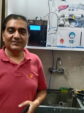 Male customer enjoying the efficiency of the Chanson Quality Water Purifier