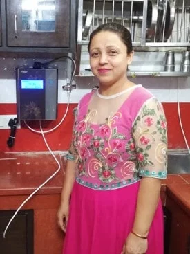 Woman operating Chanson Quality Water Purifier in her kitchen