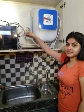 Individual standing proudly next to his Chanson Quality Water Purifier