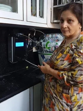 Individual standing proudly next to his Chanson Quality Water Purifier