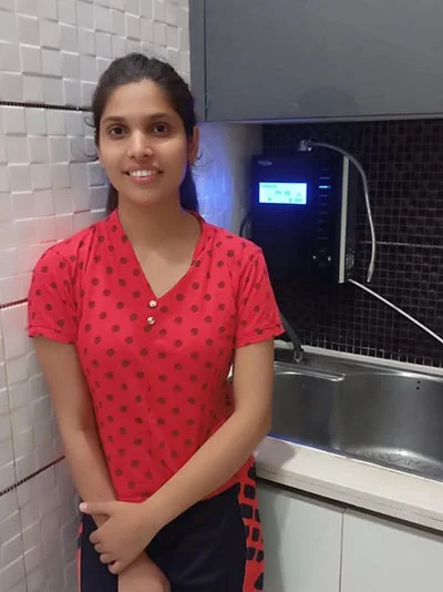 Woman operating Chanson Quality Water Purifier in her kitchen