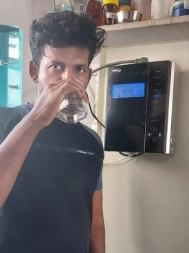 Man quenching thirst with water from the Chanson Quality Purifier