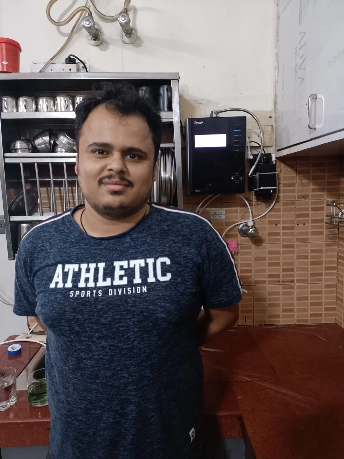 Individual with Chanson Quality Water Purifier demonstrating purified water