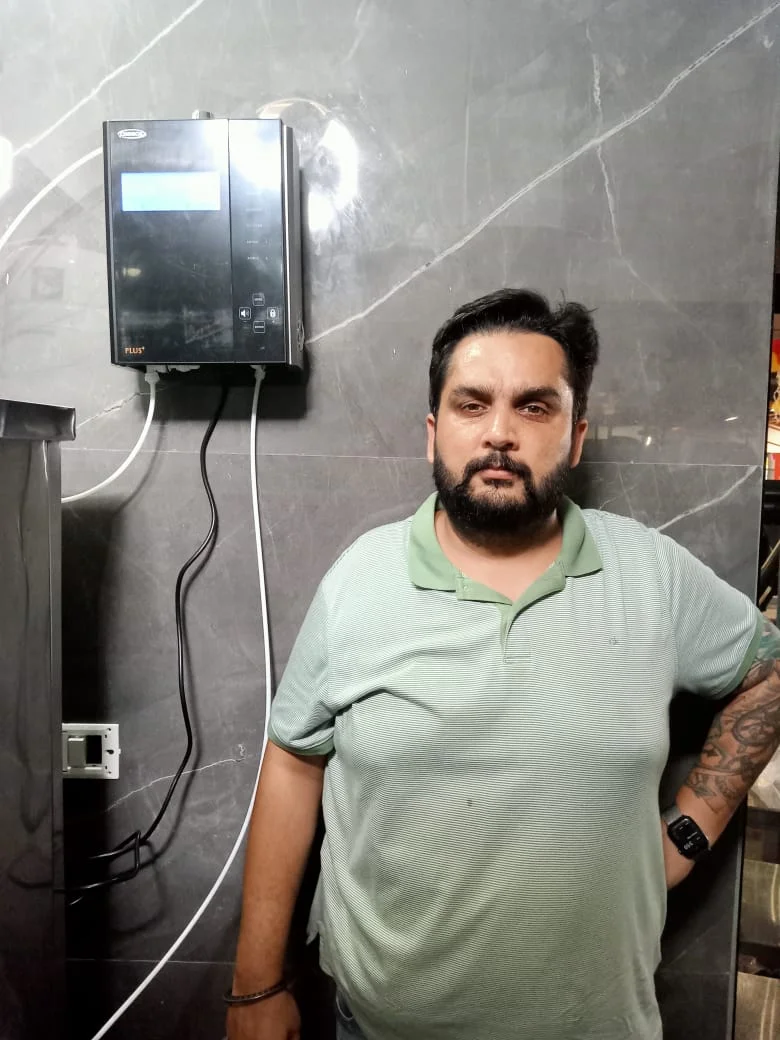 Male standing next to his trusted Chanson Quality Water Purifier