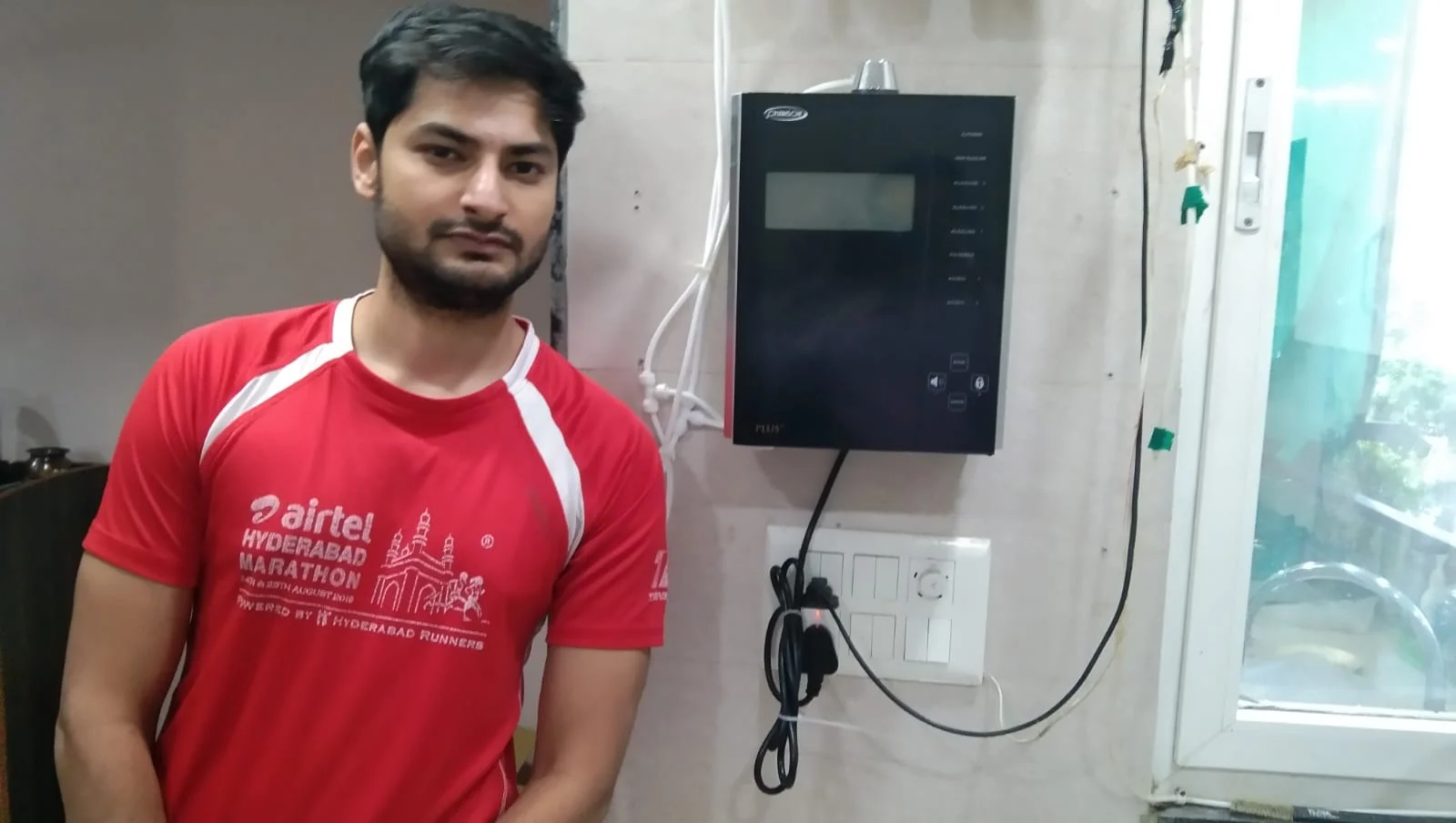 Individual with Chanson Quality Water Purifier demonstrating purified water