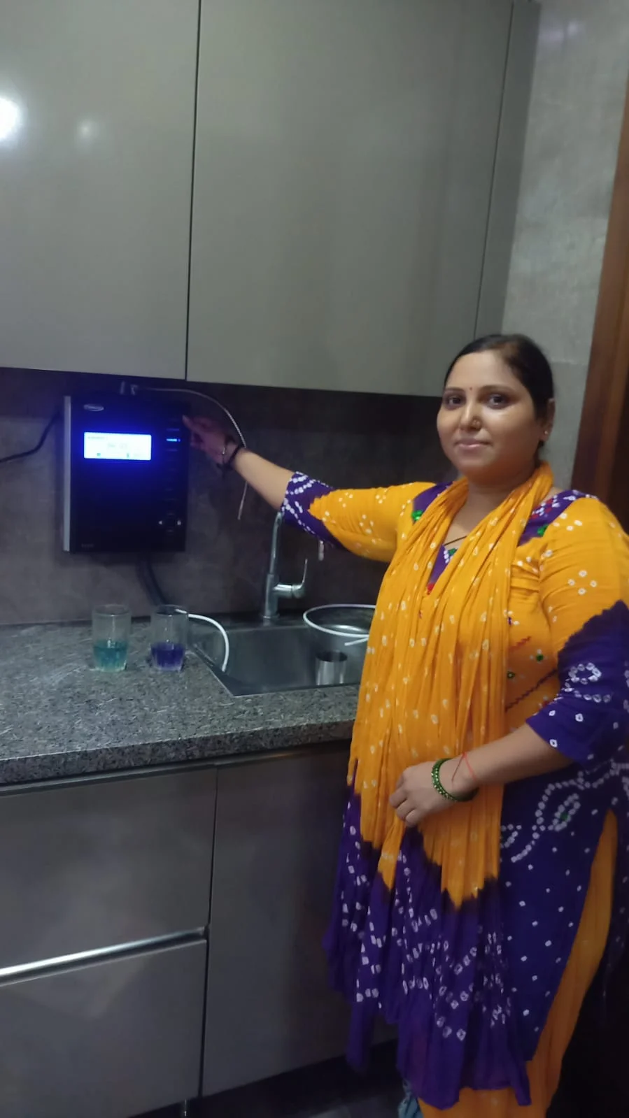 Individual standing proudly next to his Chanson Quality Water Purifier
