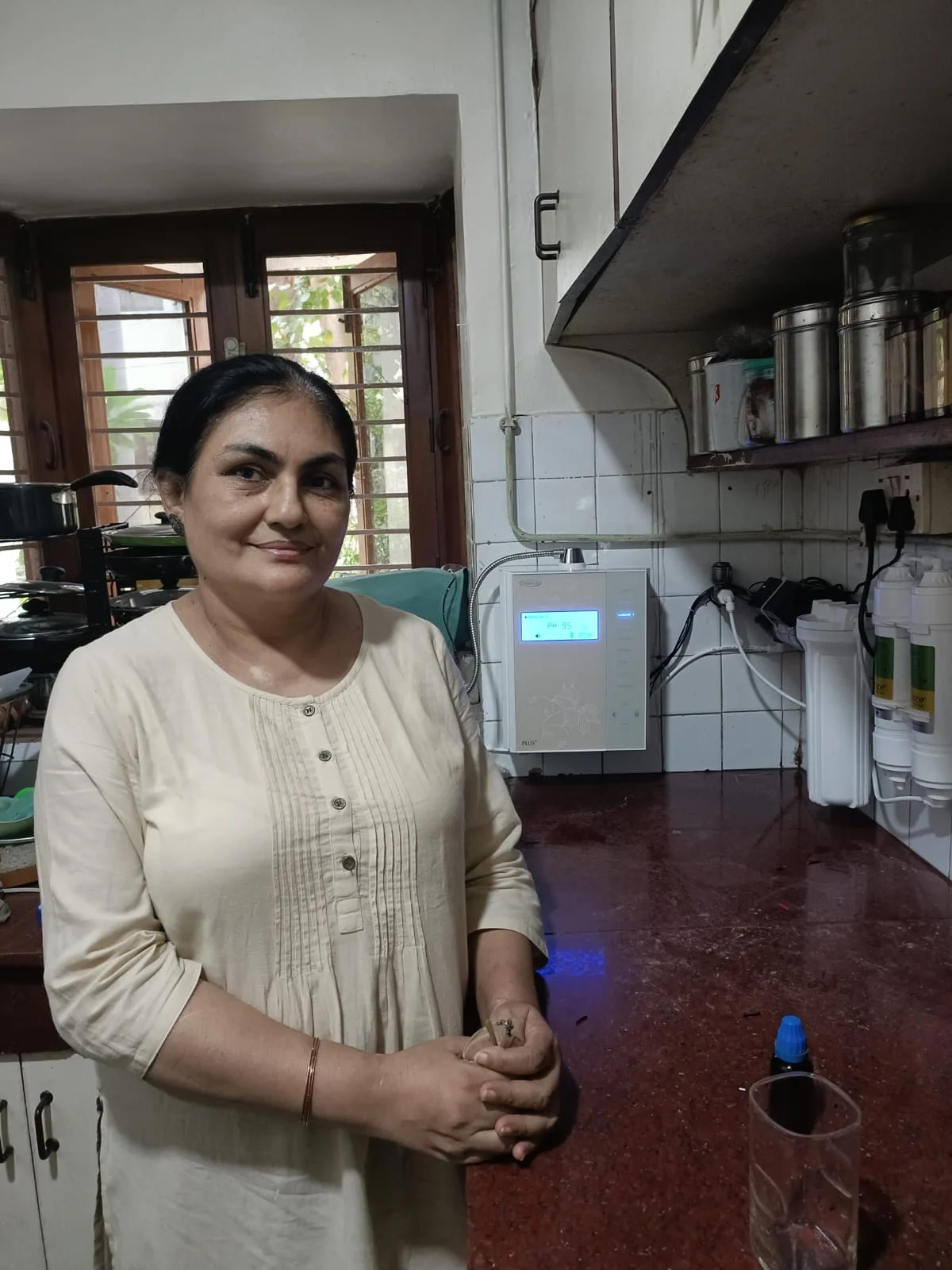 Individual standing proudly next to his Chanson Quality Water Purifier