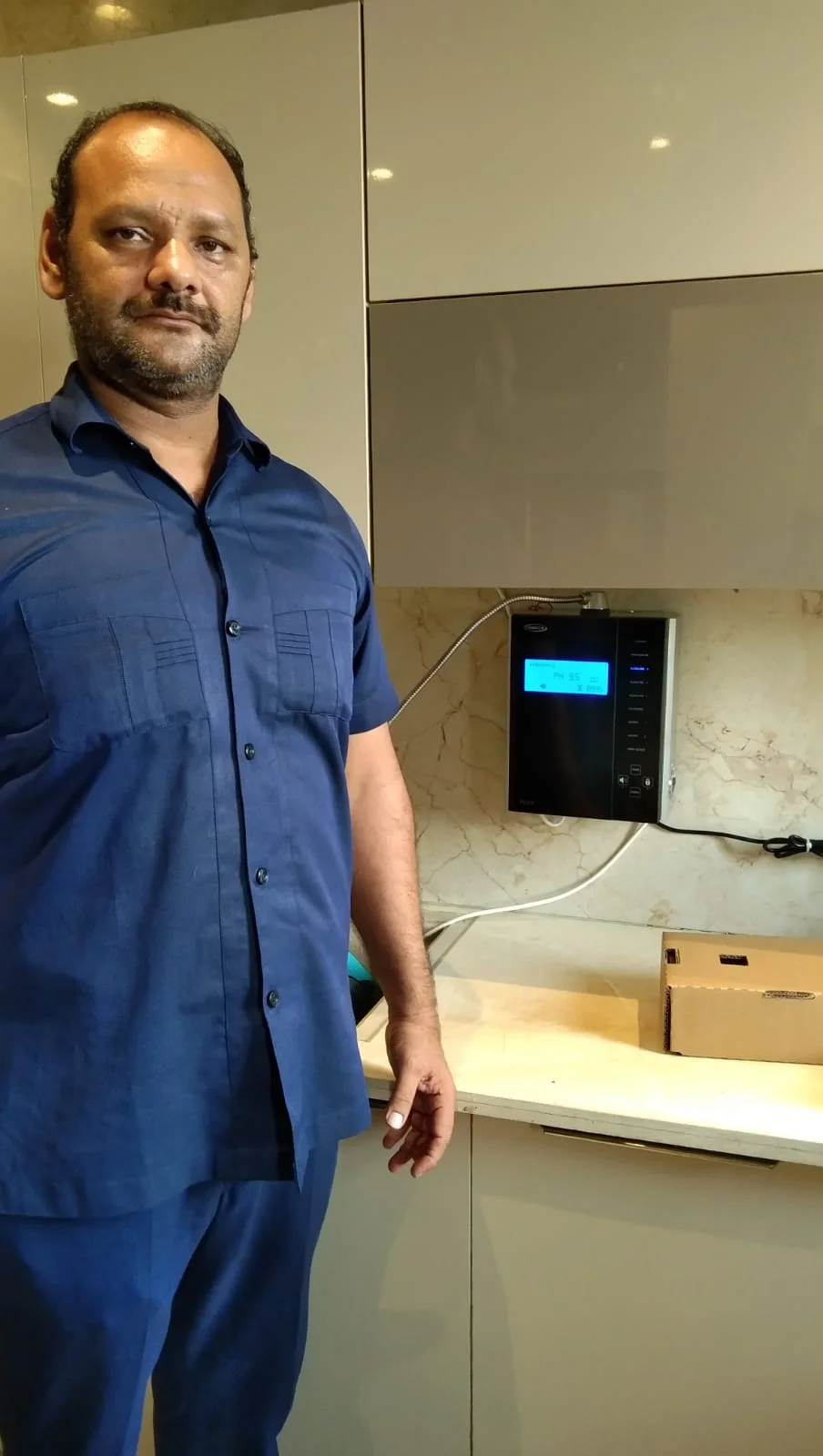 Individual with Chanson Quality Water Purifier demonstrating purified water